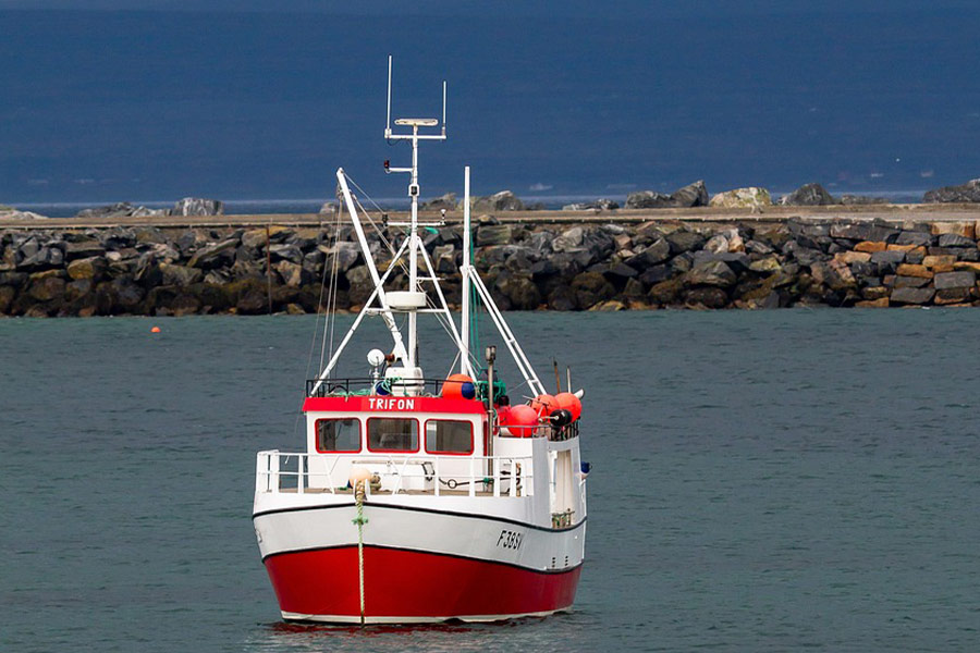 Weiß-rotes Fischerboot vor Anker