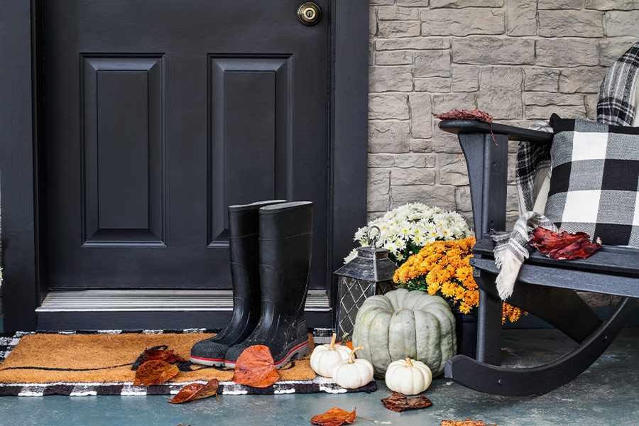 Front porch decorated for autumn with buffalo plaid