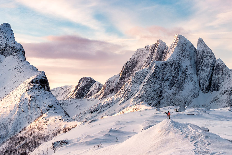 Mountain climber on top of snowy mountain range