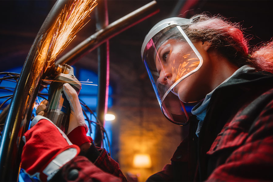 Close up woman using angle grinder