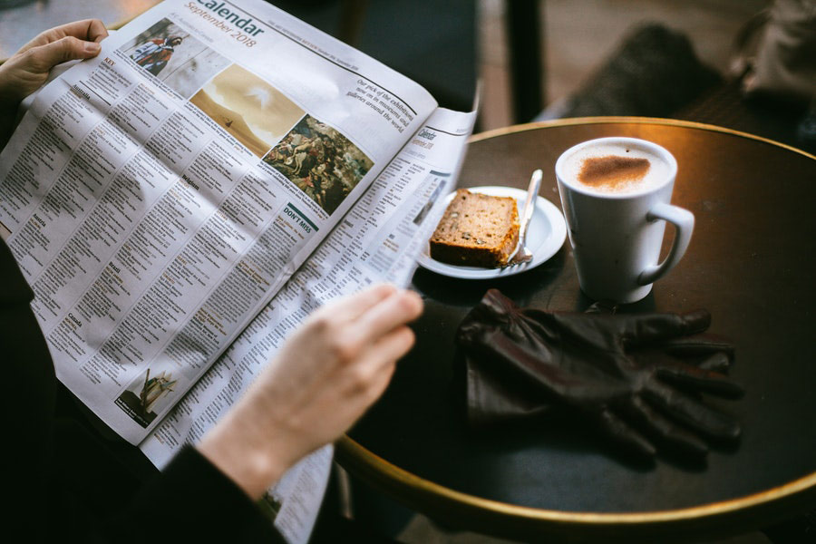 Photo of person reading with coffee bread