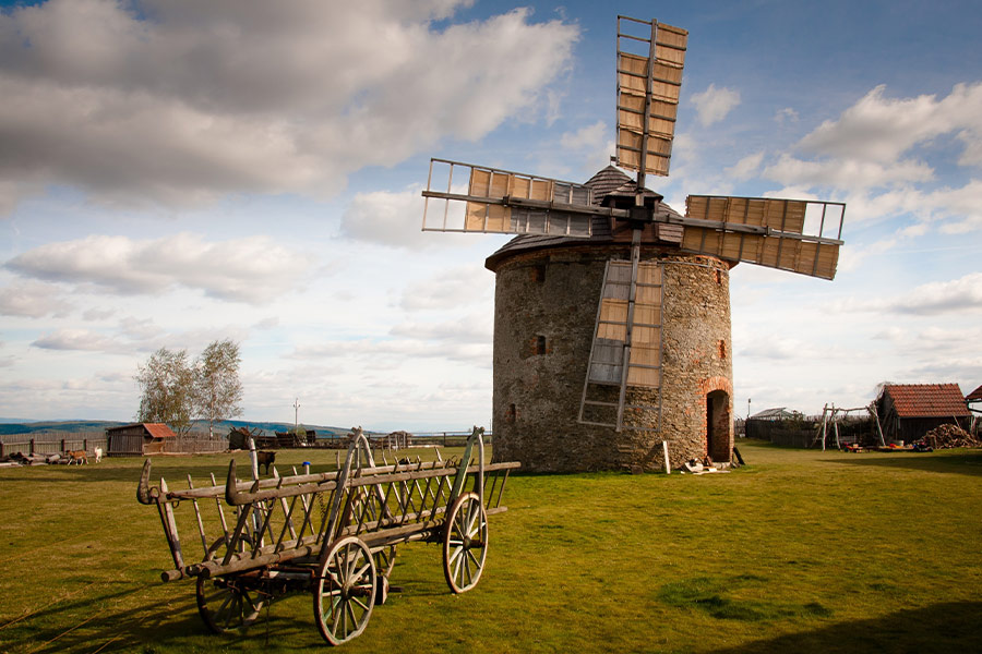 Wooden windmill near wooden carriage