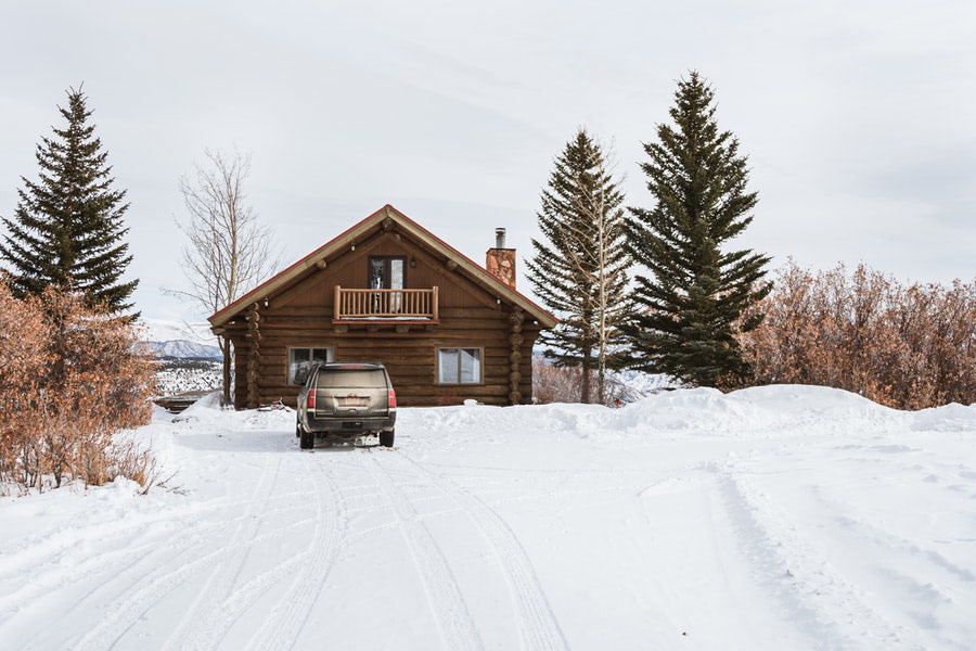 Brown wooden house on snow covered ground