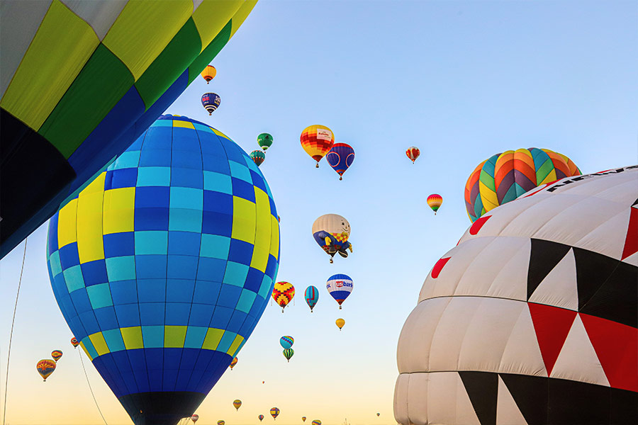 Low angle shot of airborne multi colored hot air balloons