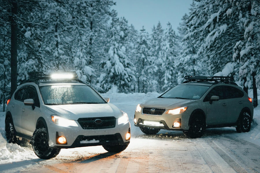 Two white suvs on snow covered road