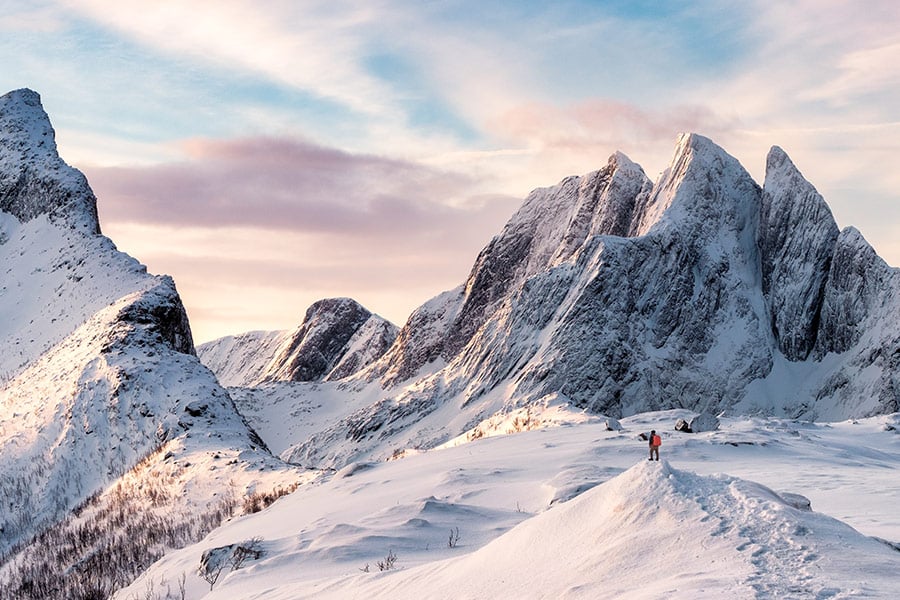 Mountain climber on top of snowy mountain range