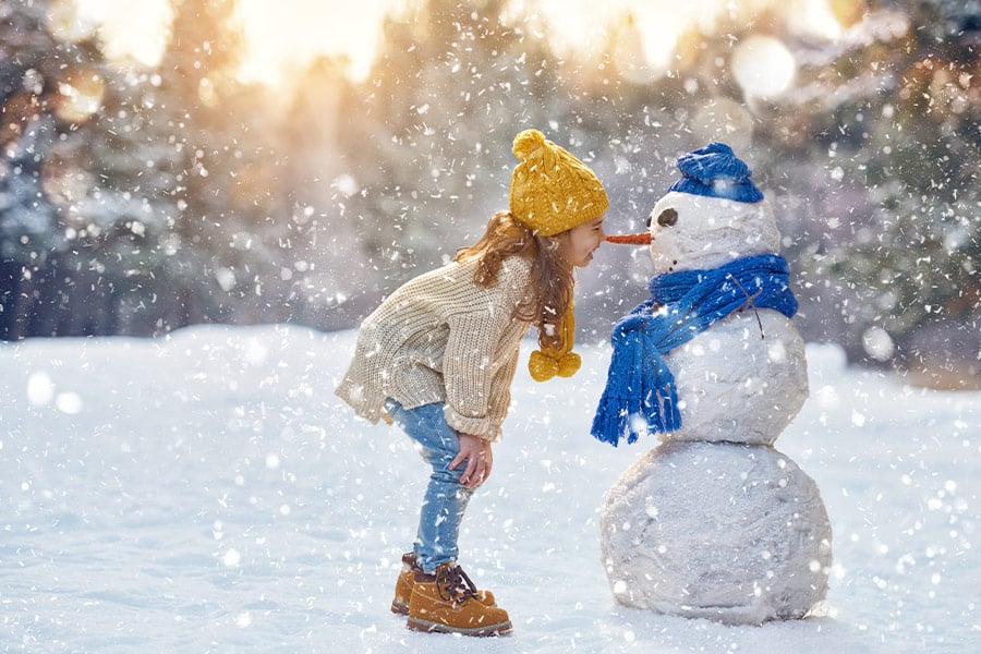 Girl paying with a snowman