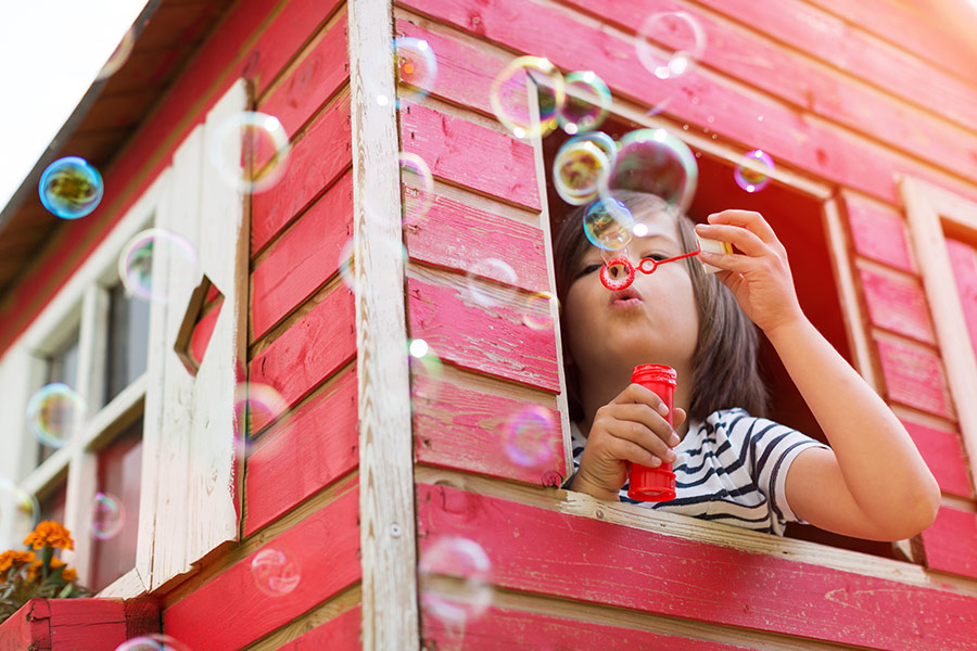 Boy blow bubbles in wooden house