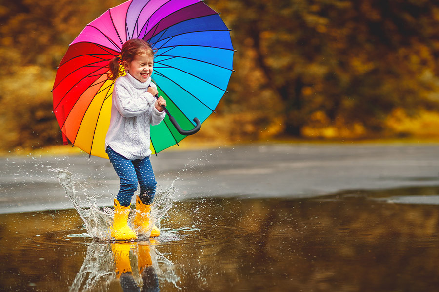 Happy funny child with multicolored umbrella