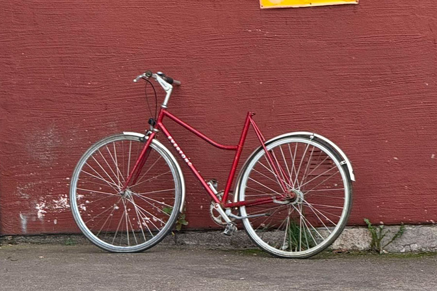 Czerwony damski rower Centurion oparty o czerwoną ścianę