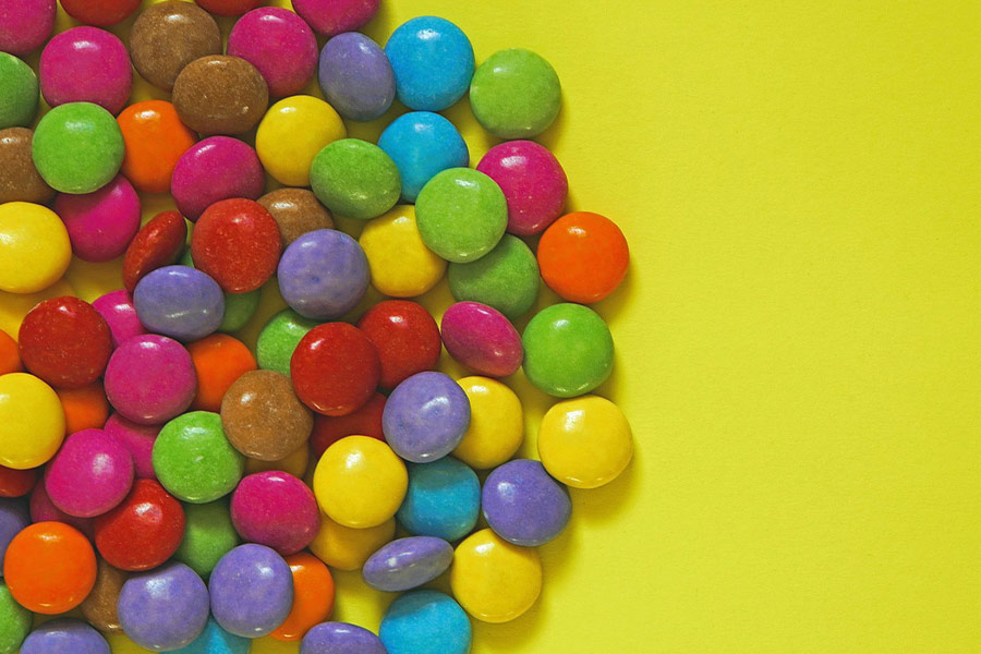 Kleurrijke smarties op gele achtergrond