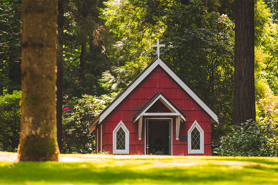 Red chapel on grassy field