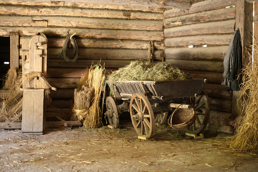 Wooden cart with hay in old barn
