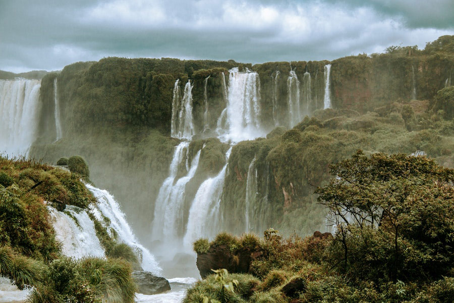 Water falls under cloudy sky