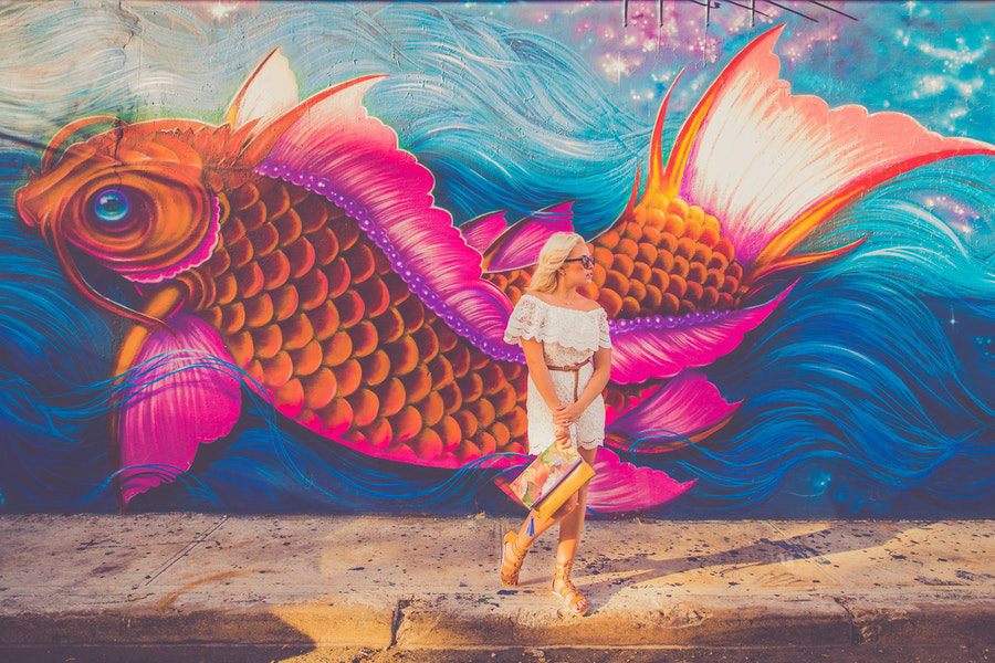 Woman standing near fish graphic wall