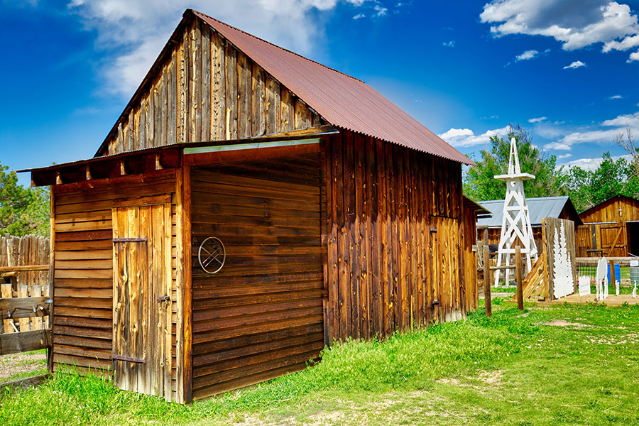 Brown wooden barn under blue sky