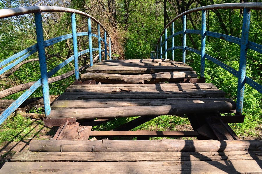 Dilapidated wooden bridge in forested area
