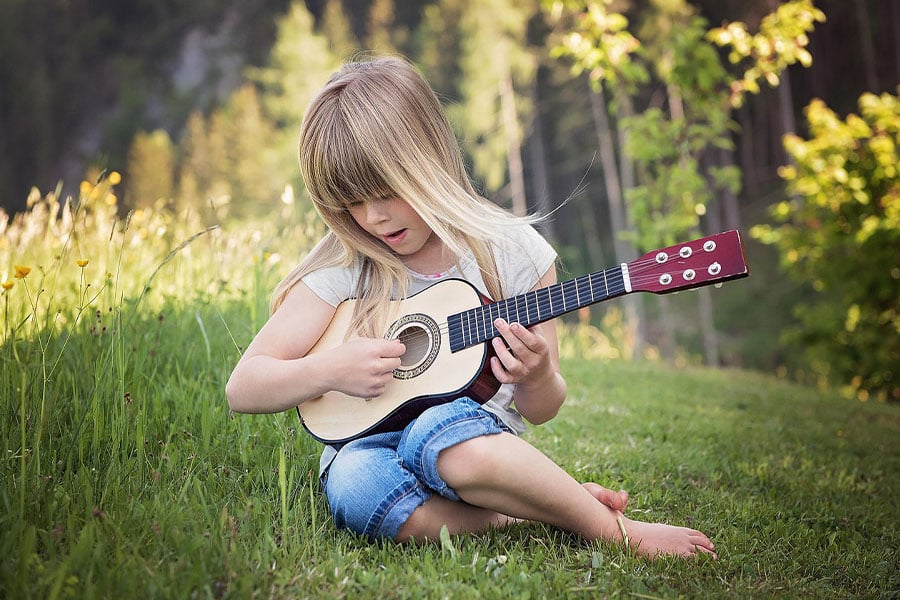 Young girl playing small guitar