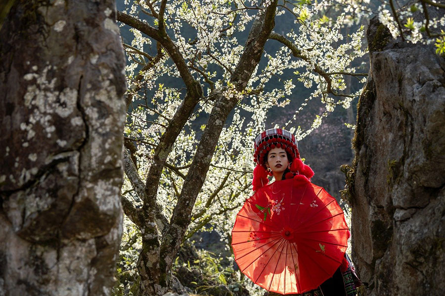 Mujer con ropa tradicional con sombrilla roja