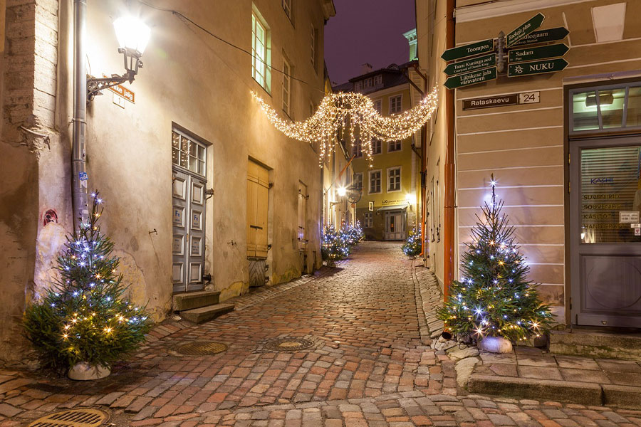 Accogliente stradina acciottolata di Tallinn, Estonia, con decorazioni natalizie