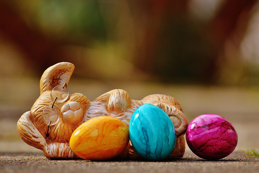 Uova multicolori per Pasqua e statua di coniglio