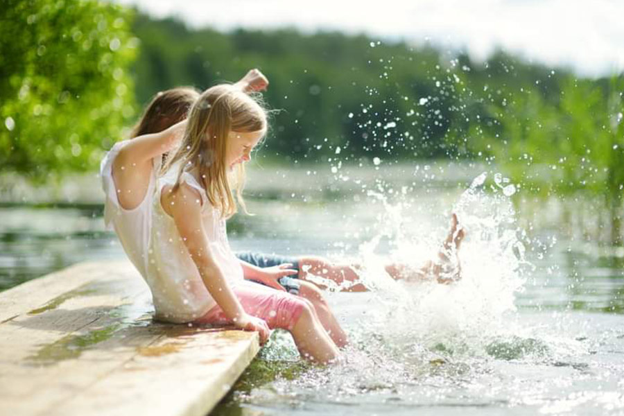In estate i bambini giocano al lago d'acqua