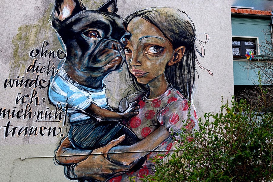 Mural de una niña sosteniendo un perro
