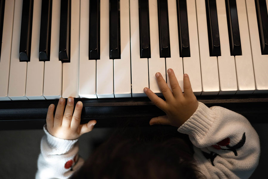 Primer plano de un niño pequeño tocando el teclado.