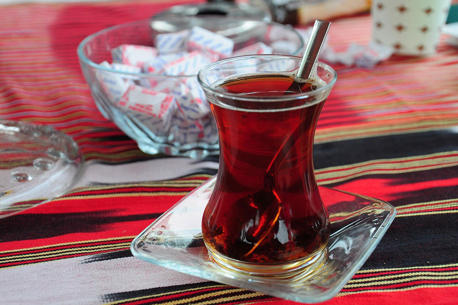 Té turco tradicional servido en un pequeño vaso con forma de tulipán.