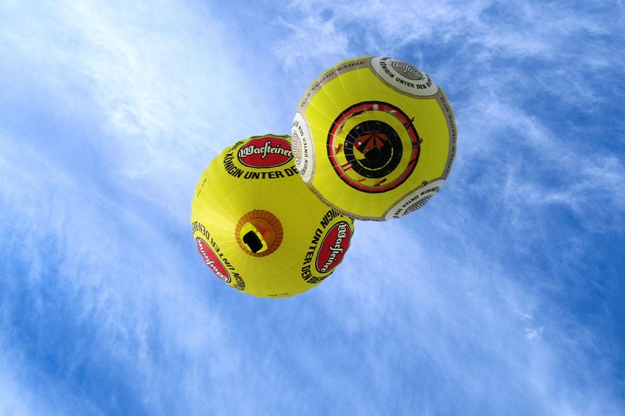 Dos globos aerostáticos amarillos con el logotipo de la cerveza Warsteiner.