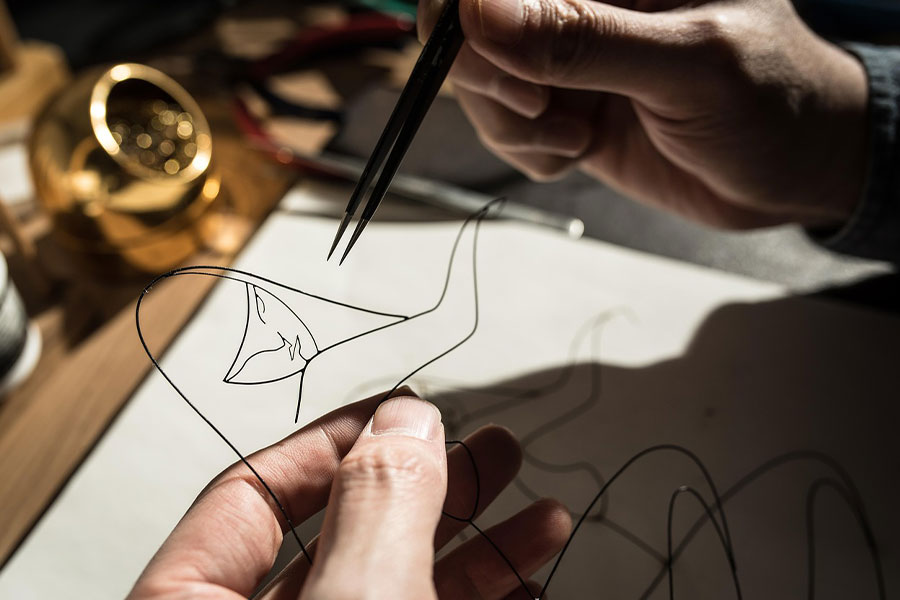 Proceso artesanal de elaboración de una escultura de alambre.