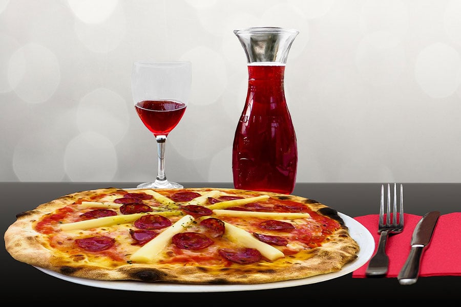 Pizza servida con vino tinto