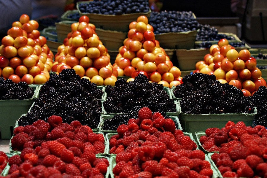 Surtido colorido de frutas frescas presentadas en cestas.