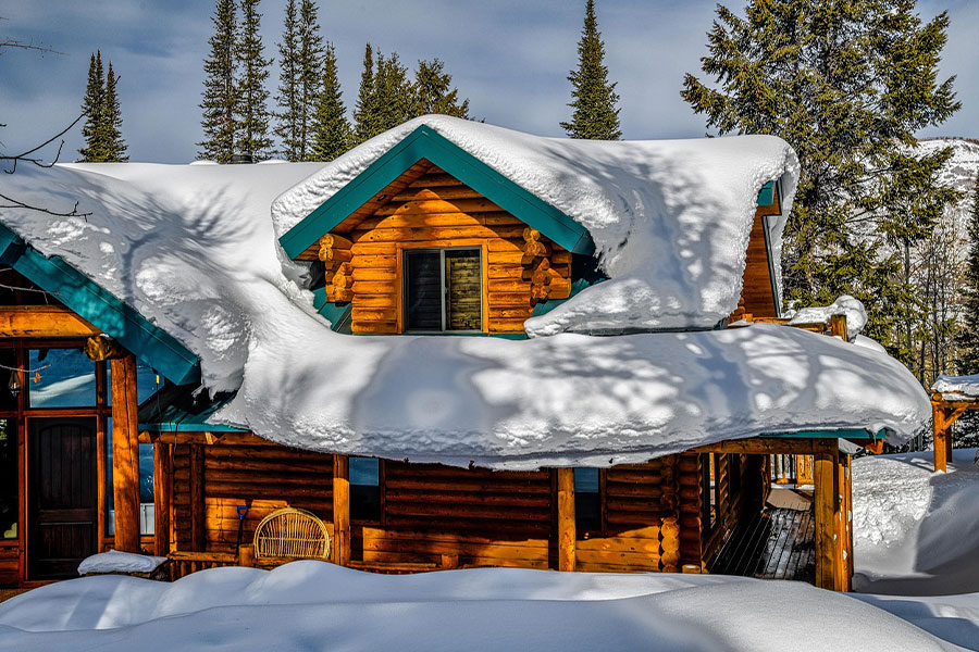 Tronco de cabaña cubierto de nieve