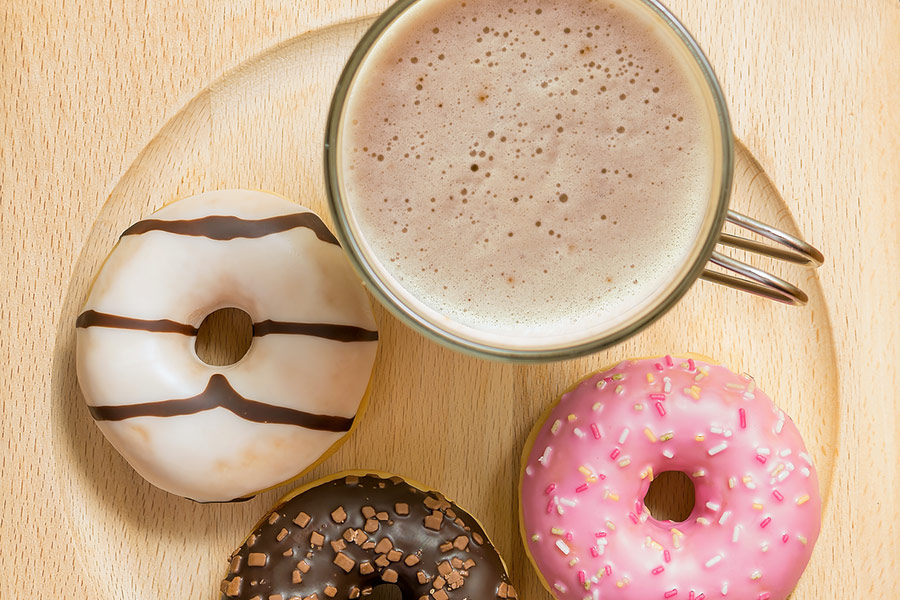 Kaffee und drei Donuts Holzteller